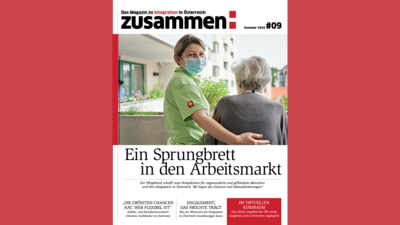 Eine Pflegekraft spricht mit einer älteren Person in einem Außenbereich, umgeben von Blumen und Pflanzen.