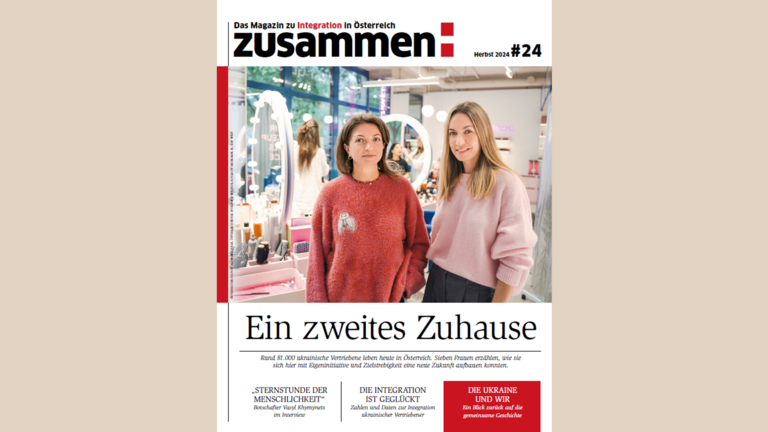 Zwei Frauen stehen in einem Kosmetikstudio vor einem Spiegel und präsentieren das Magazin „Zusammen“.