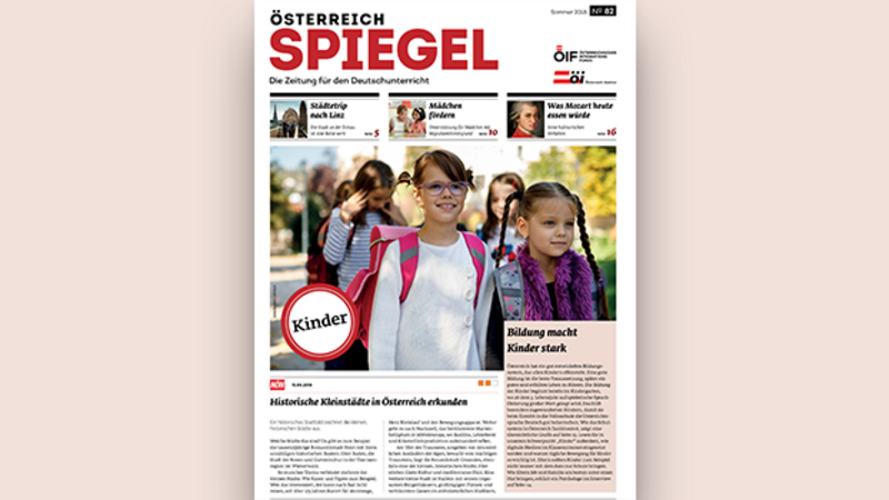 Zwei lächelnde Mädchen mit Rucksäcken auf dem Weg zur Schule, umgeben von weiteren Kindern.