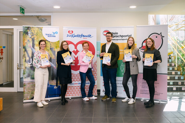 Sechs Personen halten Bücher in der Hand, umgeben von Banner mit den Logos verschiedener Organisationen.