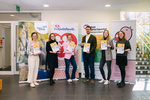 Sechs Personen halten Bücher in der Hand, umgeben von Banner mit den Logos verschiedener Organisationen.