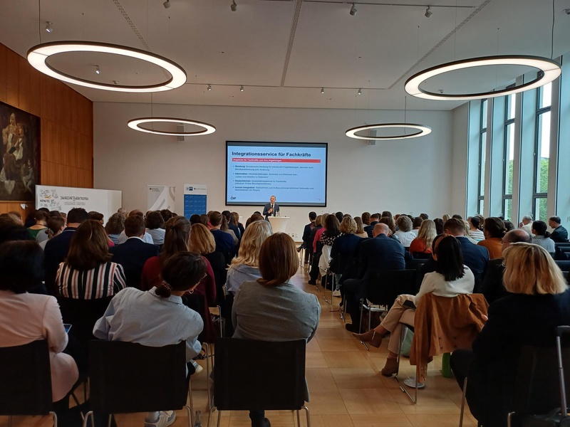 Eine Präsentation über Integrationsservices für Fachkräfte vor einem großen Publikum.