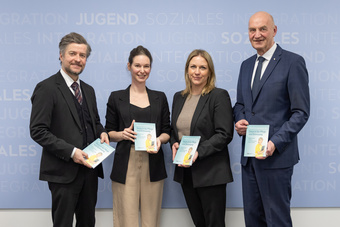 Gruppenfoto von vier Personen mit Broschüren.