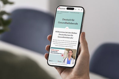 Ein Smartphone zeigt eine Webseite für Online-Deutschkursangebote für Gesundheitsberufe.