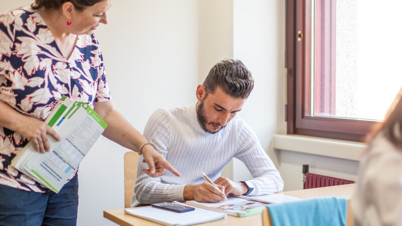 A person is learning German in an ÖIF German course.