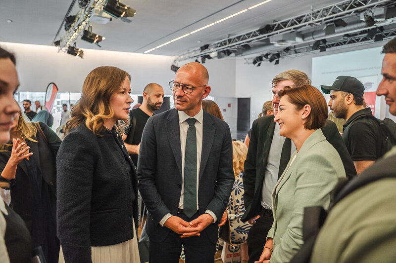 Menschen führen Gespräche und Netzwerken bei Veranstaltung in modernem Raum