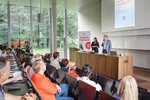 Zwei Referenten präsentieren auf einer Veranstaltung vor einem Publikum in einem modernen Saal.