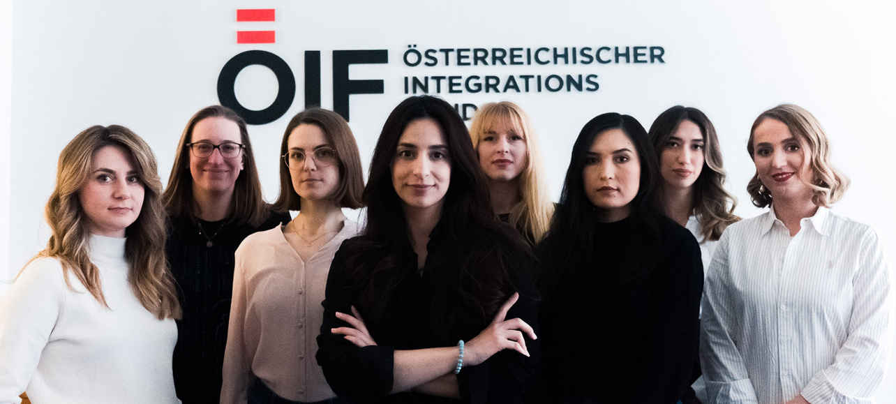 Gruppensfoto von Frauen vor einem Integrationsschild.