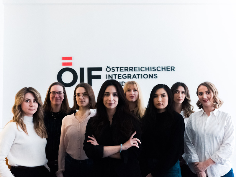 Gruppensfoto von Frauen vor einem Integrationsschild.