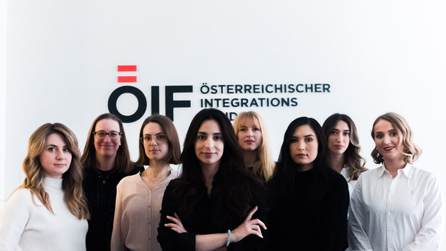 Gruppensfoto von Frauen vor einem Integrationsschild.