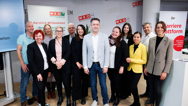 Gruppe von Personen bei einer Veranstaltung zur Karriere und Weiterbildung, mit Willkommensschildern im Hintergrund.