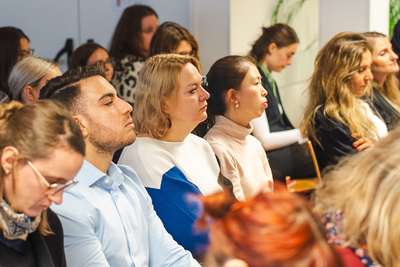 Eine Gruppe von Menschen hört aufmerksam zu, einige haben die Augen geschlossen und wirken nachdenklich.