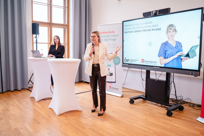 Präsentation eines Online-Kurses zum Deutschlernen für die Pflege in einem hellen Veranstaltungsraum.