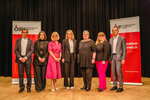 Eine Gruppe von sieben Personen steht auf einer Bühne vor bannern des Österreichischen Integrationsfonds.