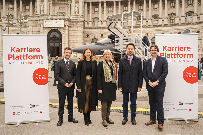 Fünf Menschen stehen vor einem Hintergrund mit Plakaten zur Karriereplattform am Heldenplatz.
