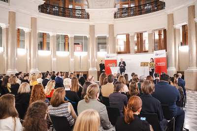 Veranstaltung mit Publikum und Rednern in einem Saal.
