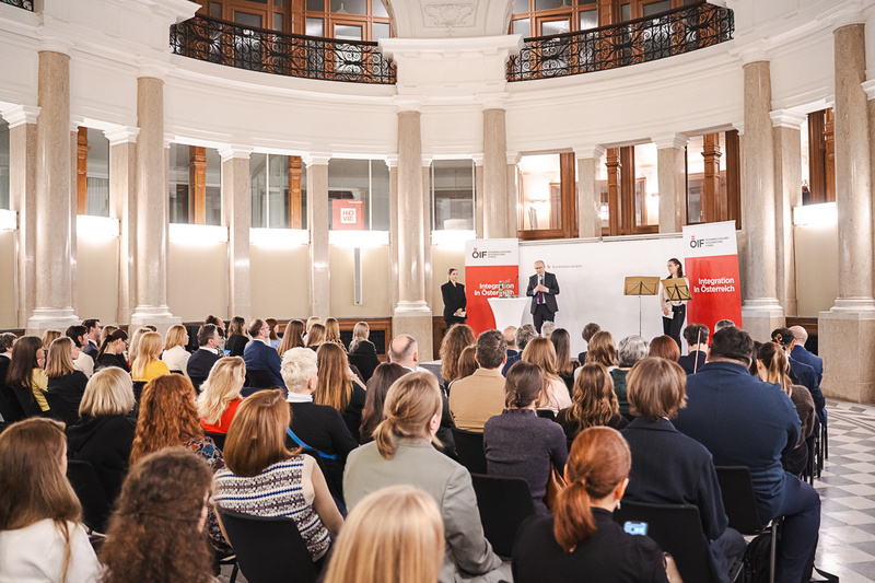 Veranstaltung mit Publikum und Rednern in einem Saal.