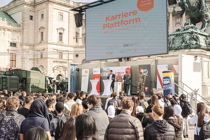 Menschen stehen vor Heldenplatz-Bühne