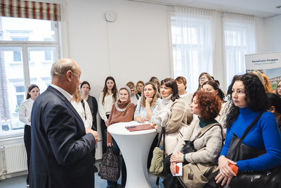 Eine Gruppe von Frauen hört einem Redner aufmerksam zu.