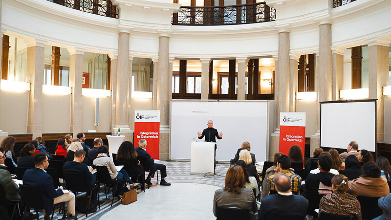 Veranstaltung mit Vortragendem vor Publikum in einem Saal.