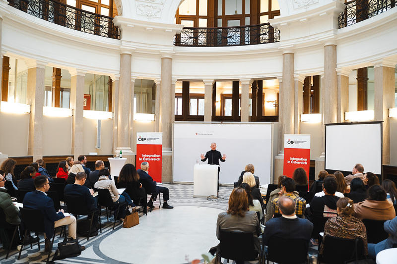 Veranstaltung mit Vortragendem vor Publikum in einem Saal.