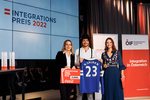 Drei Personen präsentieren den Integrationspreis 2022 und einen Fußballtrikot mit der Nummer 23.