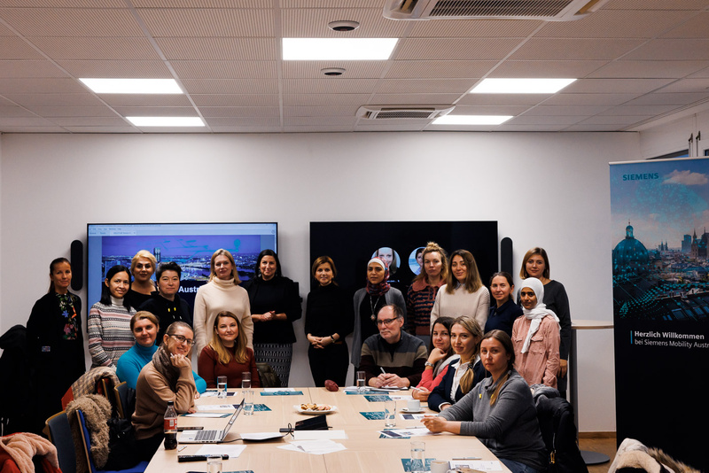 Gruppenfoto von Teilnehmerinnen und Teilnehmern in einem Besprechungsraum bei Siemens Mobility.