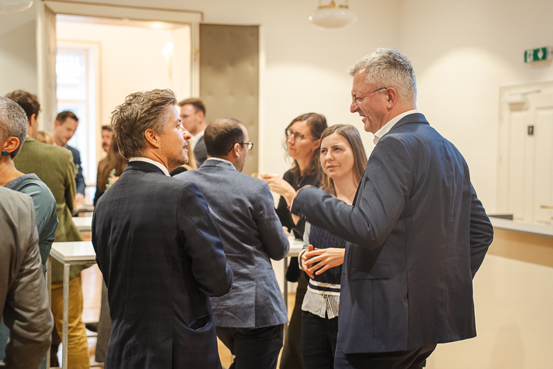 Eine Gruppe von Menschen unterhält sich in einem modernen Veranstaltungsraum.