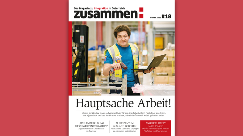 Eine Person in Arbeitskleidung hält einen Scanner und einen Laptop in einem Lager. 