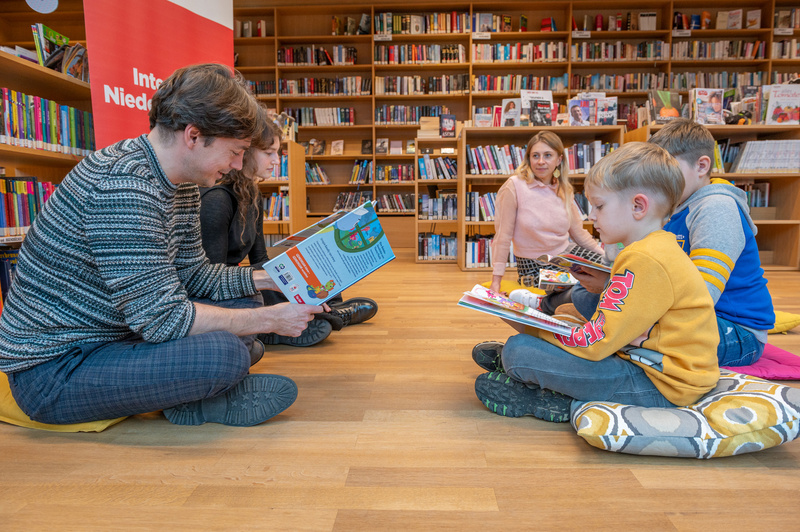 Eine Lerngruppe mit Kindern, die gemeinsam in einer Bibliothek Bücher lesen.