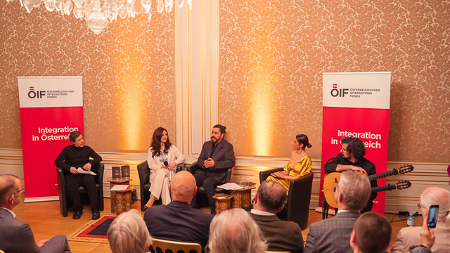 Veranstaltung über Integration in Österreich mit mehreren Sprechern und Publikum in festlicher Atmosphäre.