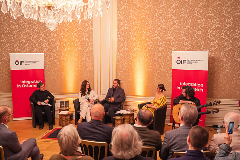 Veranstaltung über Integration in Österreich mit mehreren Sprechern und Publikum in festlicher Atmosphäre.