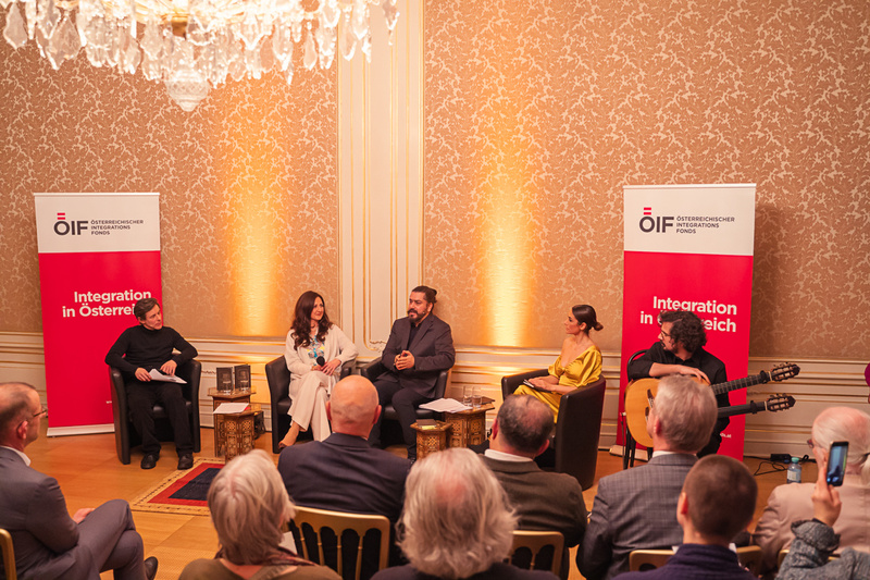 Veranstaltung über Integration in Österreich mit mehreren Sprechern und Publikum in festlicher Atmosphäre.