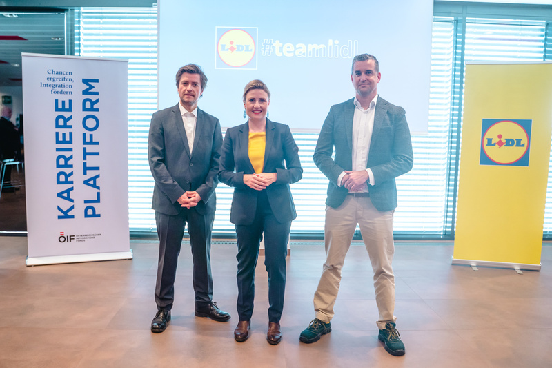 Drei Personen stehen vor einem Banner der Karriereplattform und einem Lidl-Logo.