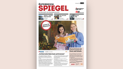 Zwei Mädchen halten ein Buch und lächeln, umgeben von kulturellen Elementen in einem Zeitungsdesign.