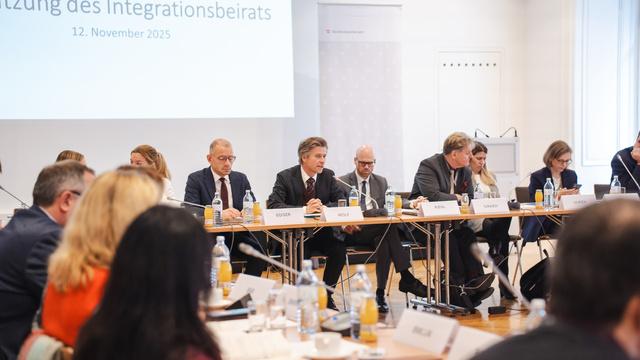 Sitzung des Integrationsbeirats mit verschiedenen Teilnehmern an einem Konferenztisch.