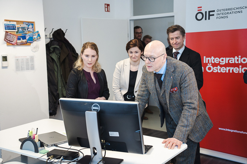 Menschen betrachten einen Computerbildschirm in einem Büro.