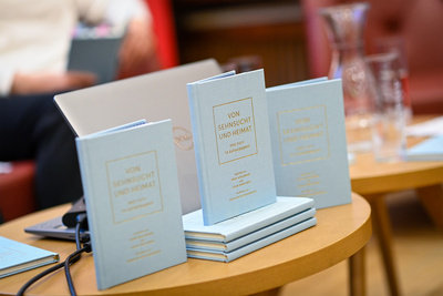 Bücher mit dem Titel "Von Sehnsucht und Heimat" auf einem Tisch platziert.