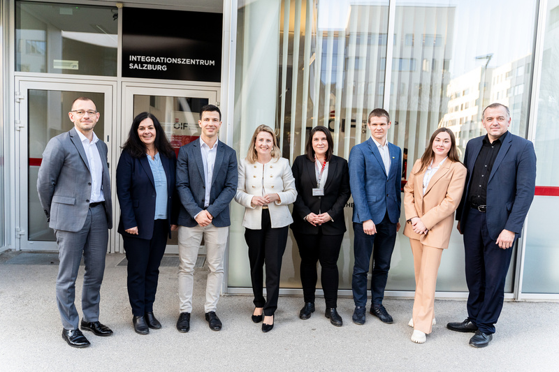 Eine Gruppe von neun Personen steht vor einem Integrationszentrum in Salzburg.