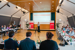 Ein Vortrag während eines Expertenforums zur Integration von Zuwanderern in Österreich, mit Publikum am Tisch.