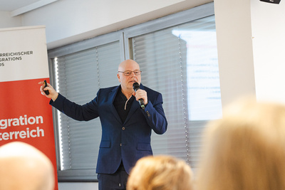 Mann spricht auf einer Veranstaltung zur Migration.