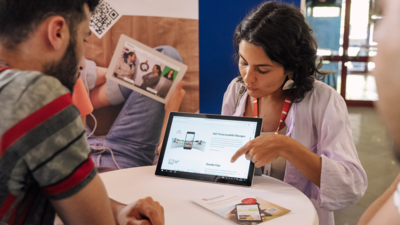 Eine Person präsentiert eine Website auf einem Tablet bei einem Beratungsgespräch.
