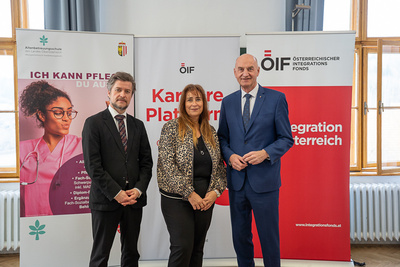 Drei Personen stehen vor Informationsbanner zur Karriere.