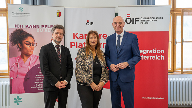 Drei Personen stehen vor Informationsbanner zur Karriere.