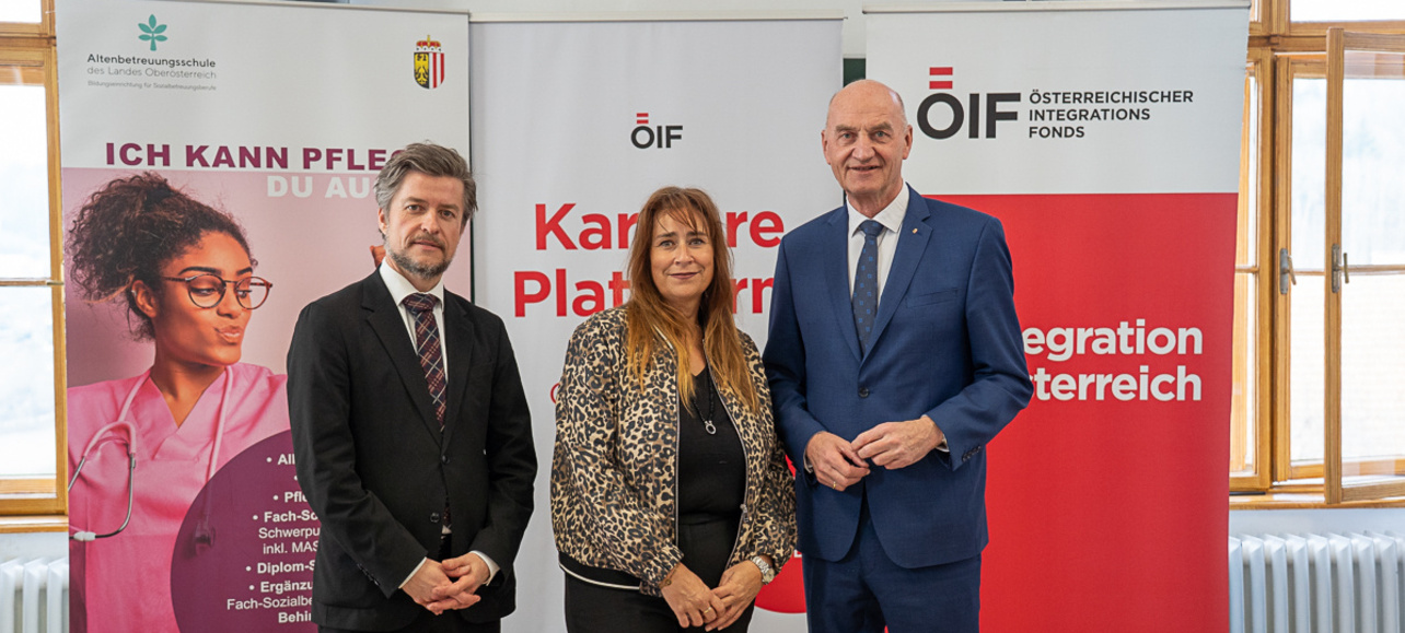 Drei Personen stehen vor Informationsbanner zur Karriere.