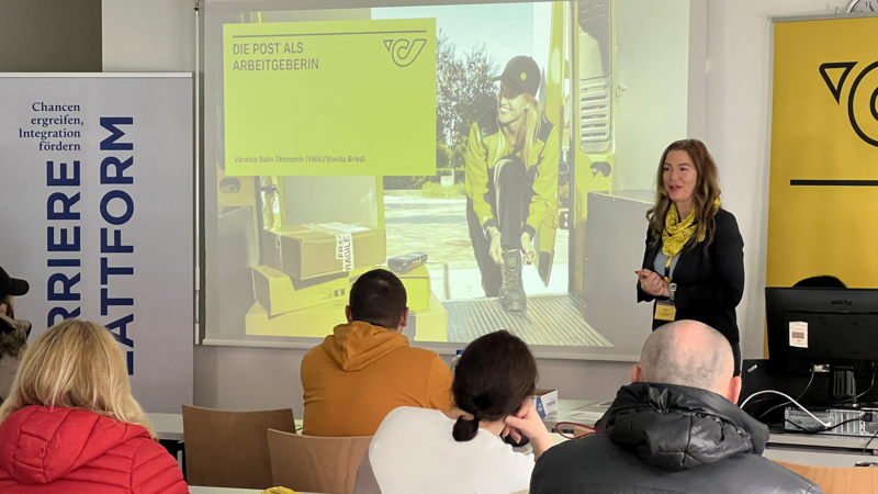 Eine Frau präsentiert Informationen zur Post als Arbeitgeberin vor einem Publikum.