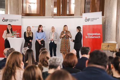Frauen auf Podium sprechen über Integration in Österreich.