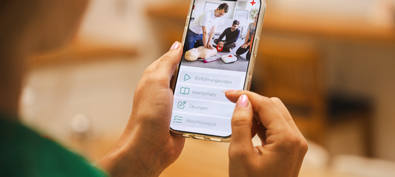 Hände mit Onlinekurs am Smartphone