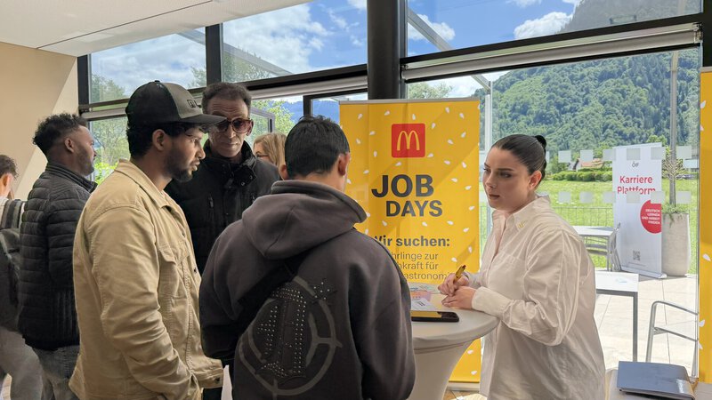 Menschen an Job-Days-Informationsstand mit Bergblick