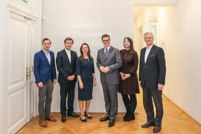 Sechs Personen posieren vor einer Wand mit dem Schriftzug 